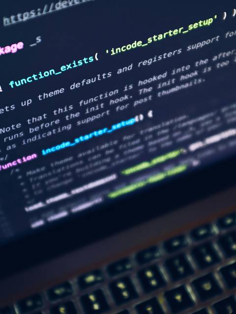 A close-up photo of a laptop screen displaying programming code.