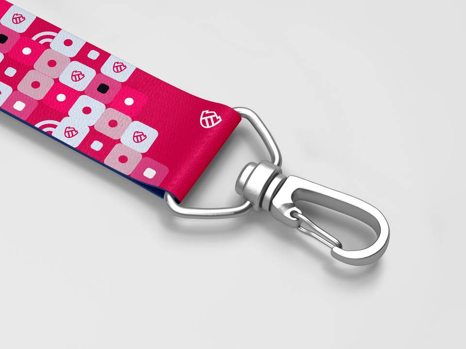 A close-up view of a pink lanyard with abstract geometric designs, attached to a silver metal carabiner.