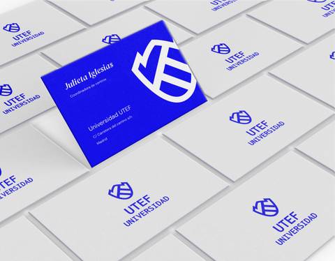 A collection of business cards spread out, featuring a blue card with a logo and details in the center.